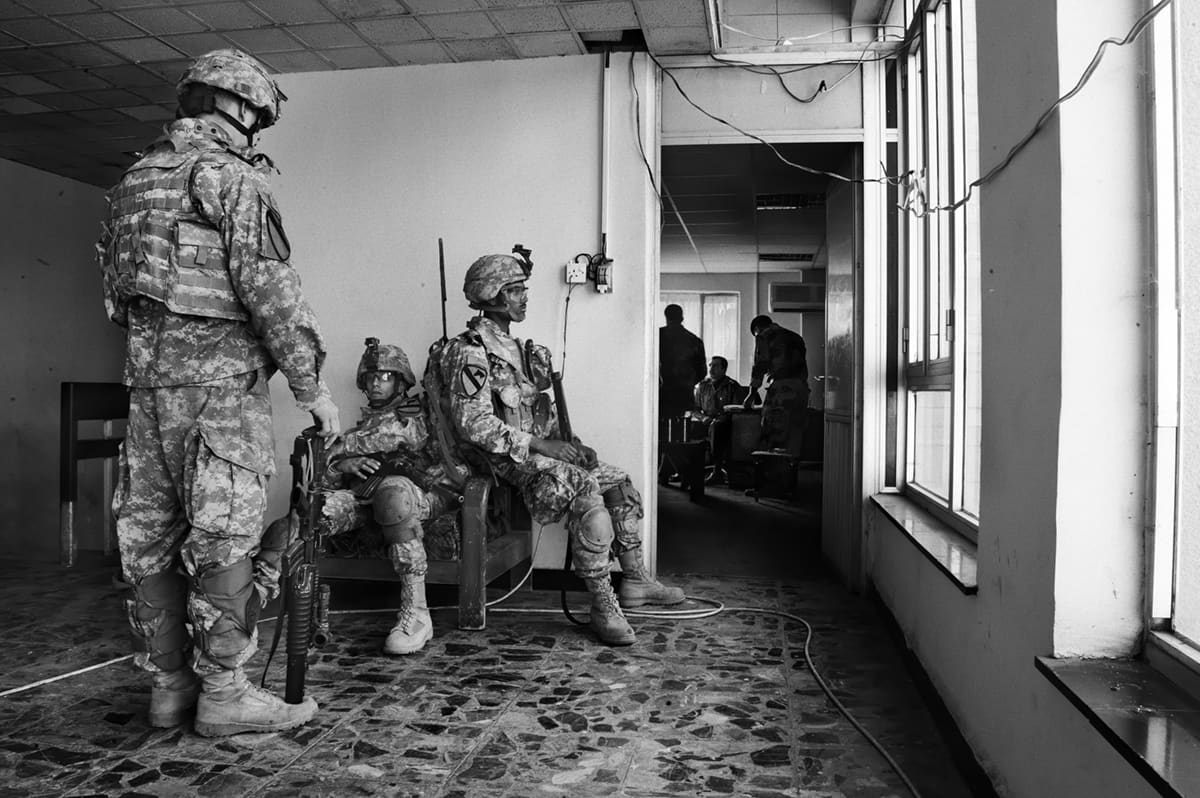 US Army soldiers waiting in an adjoining room during a meeting between their commanders and Iraqi police authorities in Baghdad
