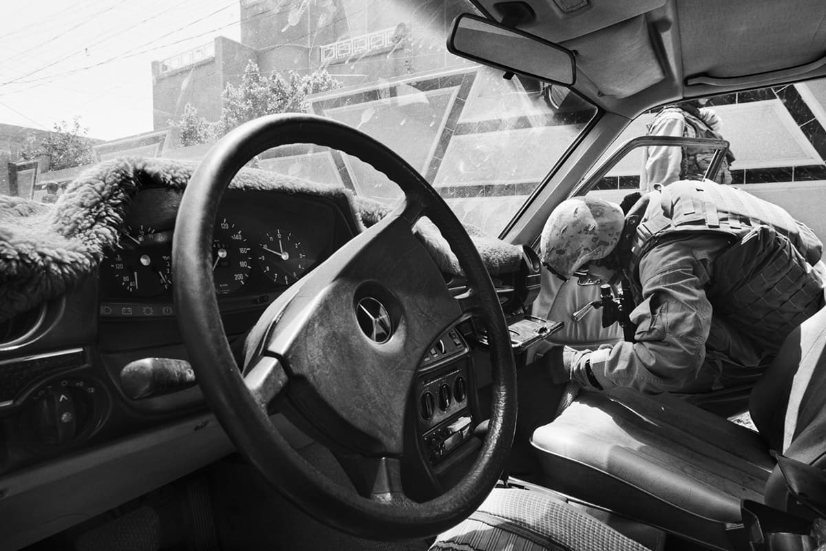A US Marine from Bravo Company searches the interior of a car from the driver's seat during a patrol in Fallujah