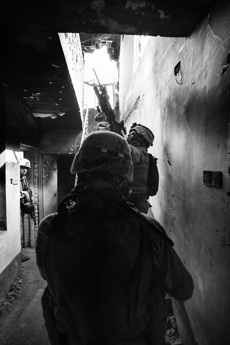 US Marines from Bravo Company advancing through a darkened corridor on patrol in Fallujah