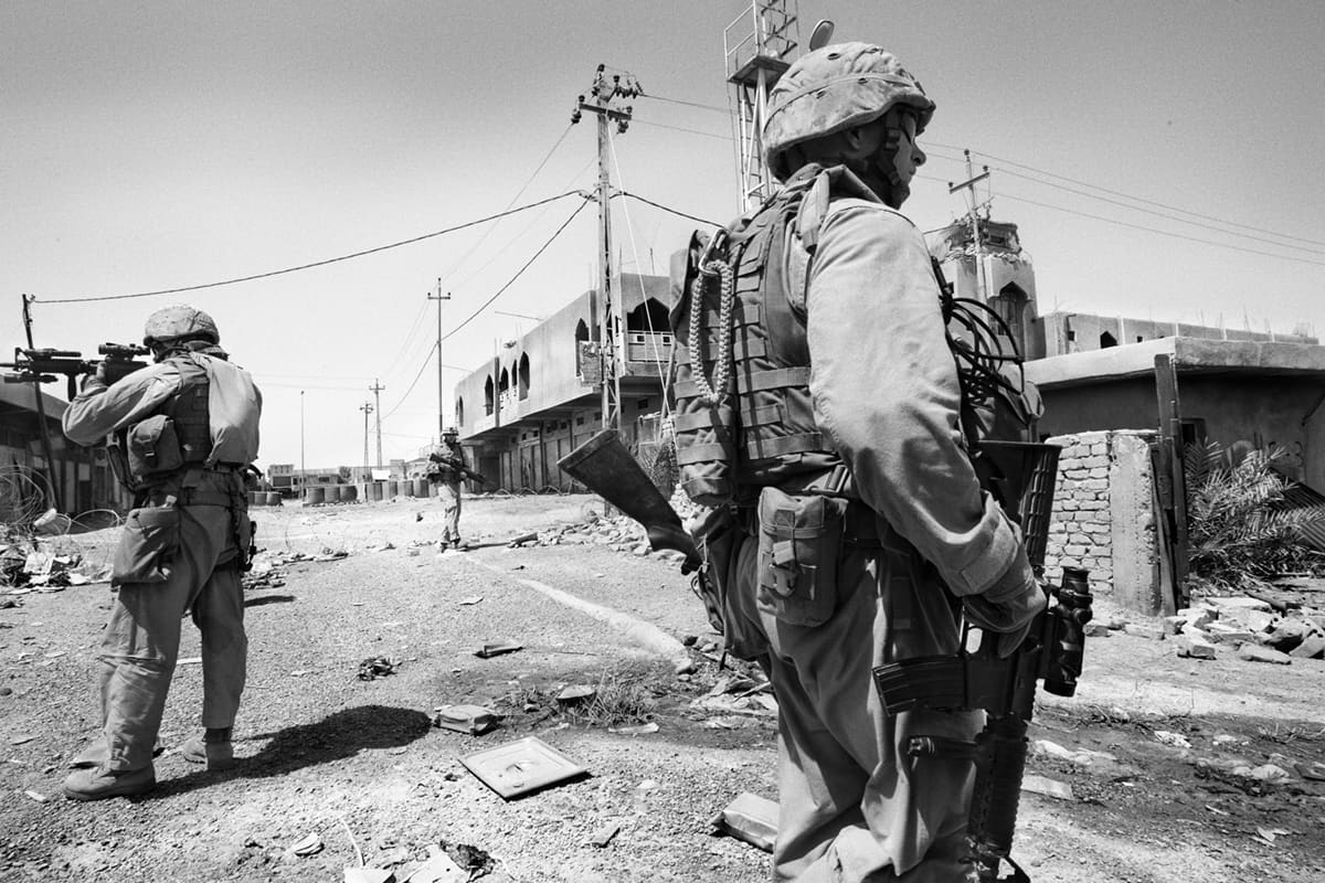 US Marines from Bravo Company advancing along a deserted street during a patrol in Fallujah — a portrait of a war turning on itself