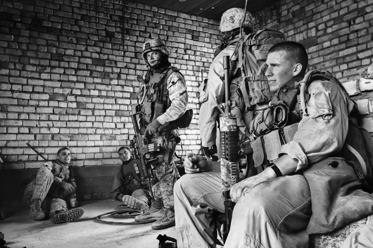 US Marines from Bravo Company resting in cover inside a building they have occupied during an operation on the outskirts of Fallujah
