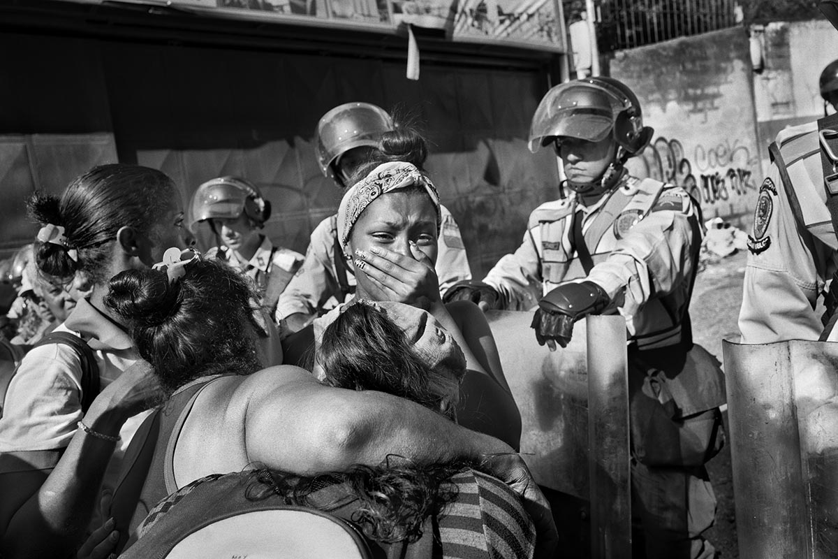 A woman cries outside a police station waiting for news of her brother during a precinct riot