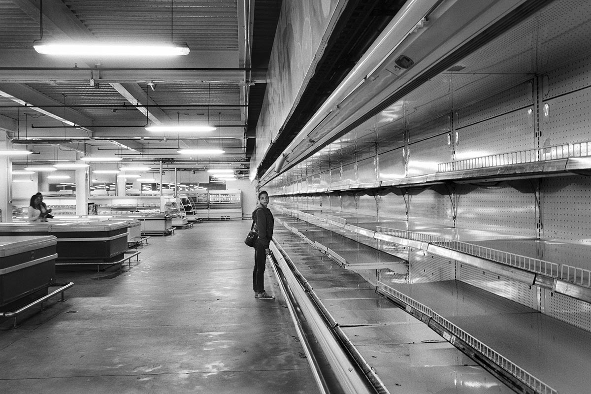 A woman stands inside a Caracas supermarket amid shortages of basic products