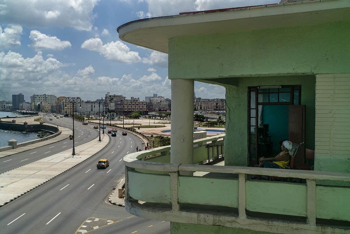 A woman on the terrace of her home overlooking the Malecón in Old Havana, Cuba.