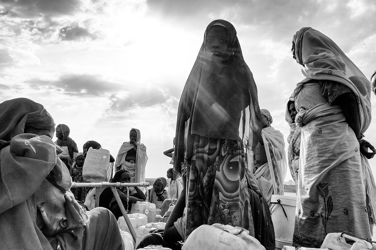 Women queueing with jerrycans at a water point in a displacement camp in Darfur, Sudan.