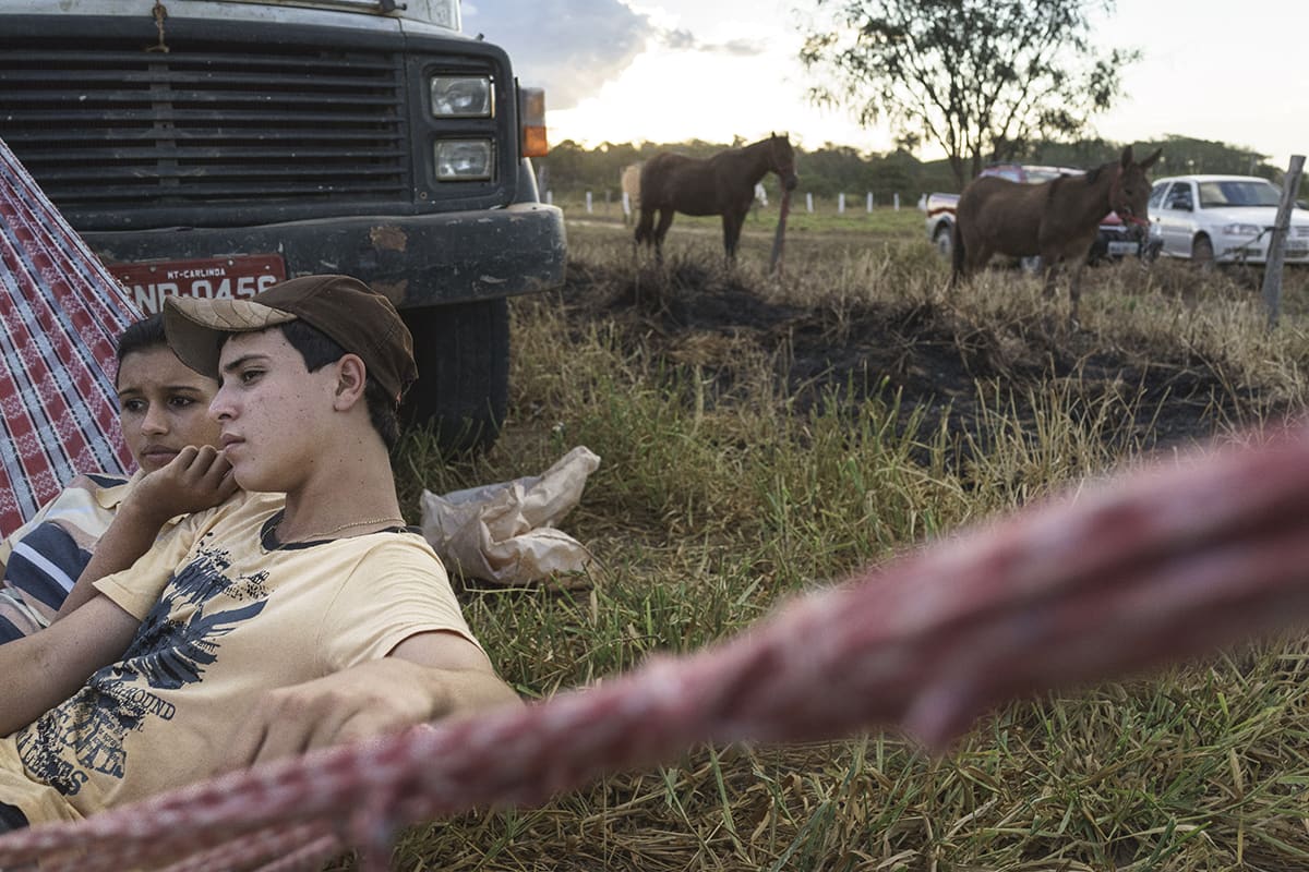 Two young men resting near a truck in a deforested area near Sipo